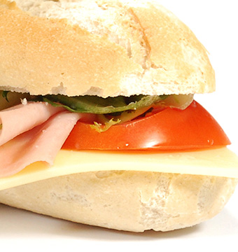 A fresh baguette with ham, cheese tomato and salad
